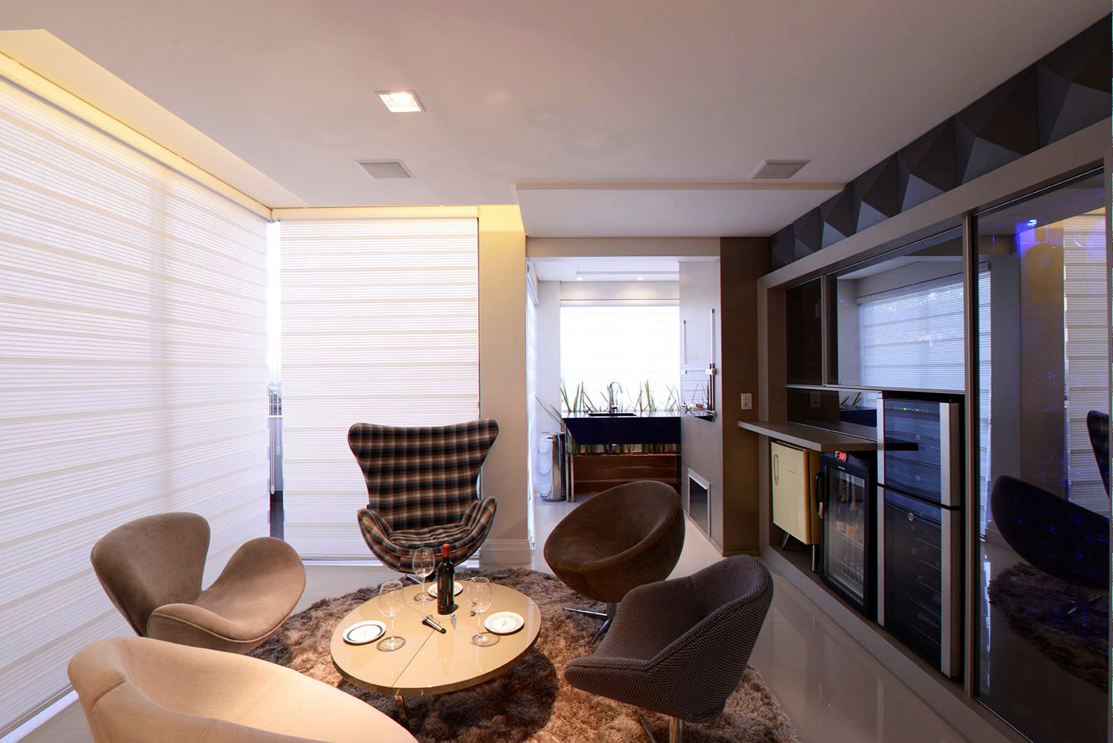 Sala de estar com persianas double vision brancas e poltronas em couro